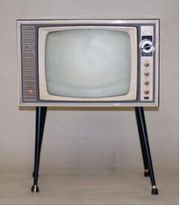 昭和40年代初頭に使用されていたテレビの写真。テレビ画面の横にダイヤル式のリモコンが付属されている。
