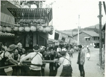 50年前のモノクロ写真で、山車を引いている人たちの様子