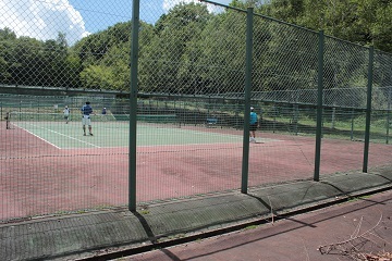 柵の外側から見たテニスコートの写真
