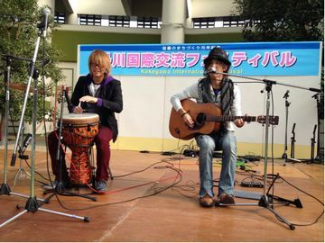 掛川国際交流フェスティバルのステージでジャンべを叩くシンくんとギターを弾きながら歌うボーカルのヒロくんの男性ユニット