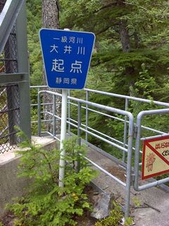 青色に白い字で一級河川大井川起点 静岡県と書かれた標識