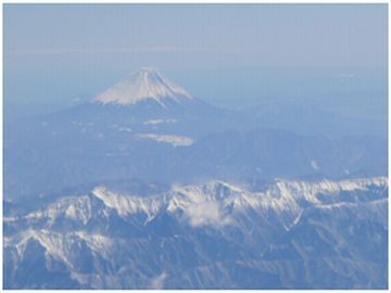 飛行機の窓から見えた富士山、手前に南アルプスの山々が見える