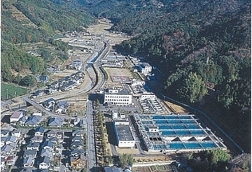 相賀浄水場を上空から撮った写真。山に囲まれたとちで、近隣には住宅がある。