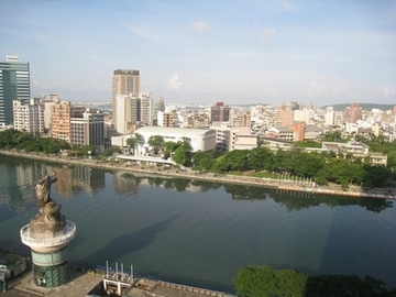 高雄市内。高台から写真を撮っている。手前に大きな川奥にビルが建つ街がある