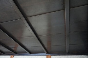 黒く落ち着いた色合いの天井板に柱の影が映りこんでいる
