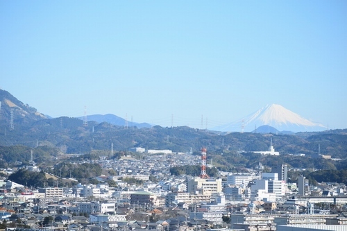 ビルや建物、山の奥に富士山が見える写真