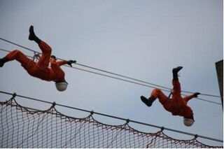 ロープブリッジ救出競技で隊員2名がロープにぶら下がり移動している