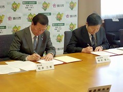 掛川市長と静岡労働局長が協定書に署名する様子