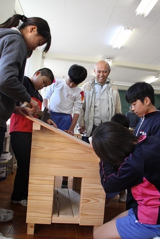 トンカチなどで木材に釘を打ち付け、ウサギの飼育小屋を作る小学生