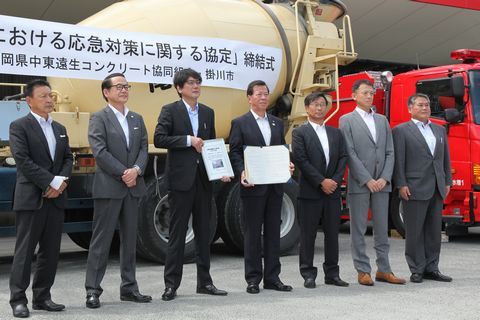 ミキサー車の前で協定書を披露する松井市長と組合員