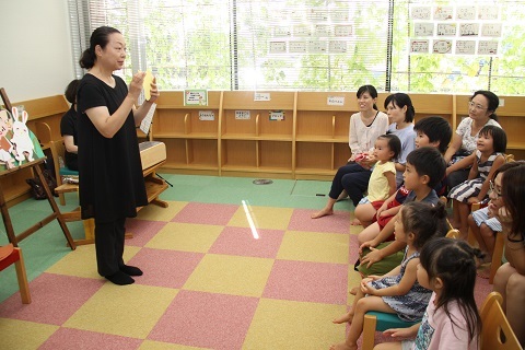 三浦さんの読み聞かせを楽しそうに聞いている子供たちと参加者