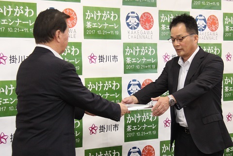 松井市長から認定証を両手で受け取る日東工業執行役員の飯田英人さんの写真