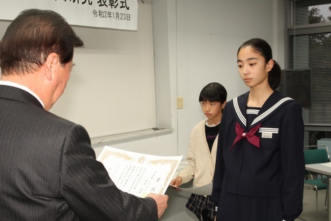 賞状を読み上げる松井市長と手渡されるのを待つ新田さん