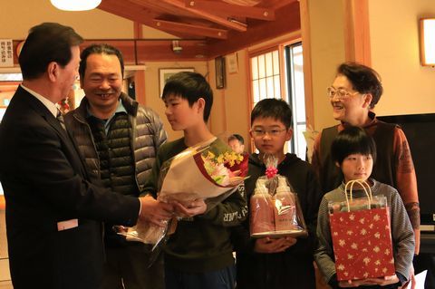松井市長と、花束や記念品を受け取る高橋さんの家族の孫3人と祖父母