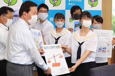 北中学校生徒全員で、ゴミ削減プロジェクトに取り組み作成したポスター4種類を北中学校生徒会役員の5名が松井市長に披露している様子