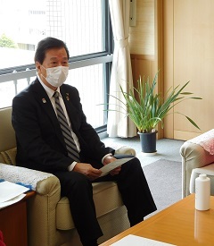消毒液の説明を受けるマスクを付けた松井市長の写真