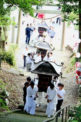 六所神社の石段を上る3体の神輿と神輿を運ぶ人々
