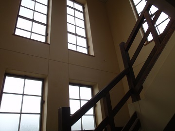 2階へ向かう階段に設置された縦長の窓から日差しがたっぷり入ってくる様子