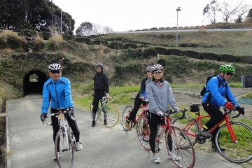 トンネルをバックに、自転車にまたがった参加者たちの画像