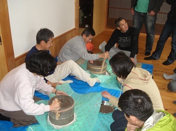 石臼ひいてそば粉を作っている人たちの画像