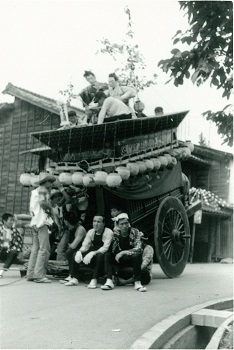 50年前のモノクロ写真で、止まっている山車に人が座っている