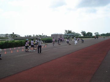 コース上にコーンを立てて一輪車を練習する人たちの画像