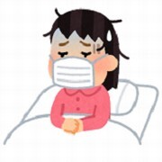 体の調子が悪い女の人が布団の中ででマスクをしている