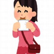 女の人が歩きながらうれしそうに食べ物を食べている