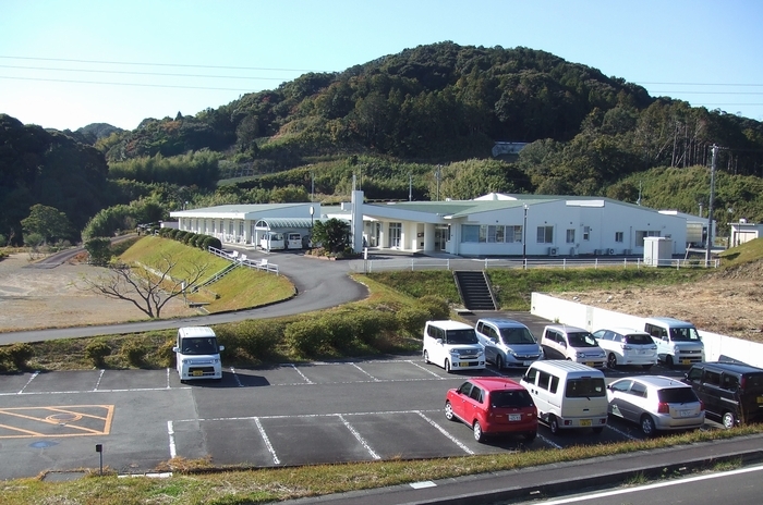 小笠老人ホームの建物とその前にある駐車場の写真