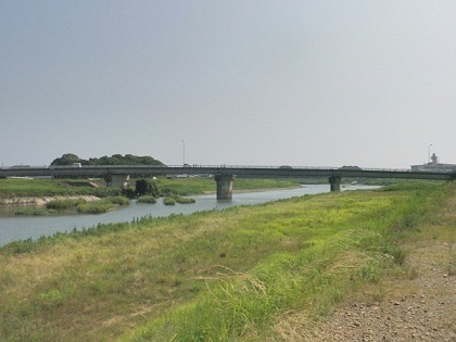手前に河川敷が見える河川に架かる鹿島橋の写真
