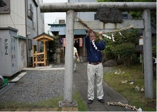 鳥居のしめ縄を交換しするようす