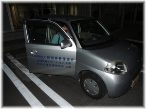 暗い中車に乗り込む職員の写真
