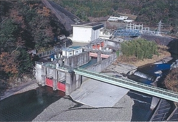 川口本取水口を上空から撮った写真。建物は、山に囲まれたところにある。