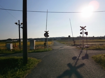 田園地帯の中にある踏切の写真