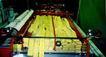消防車上部の写真。連結されたホース、吸管、サーチライトが搭載されている。