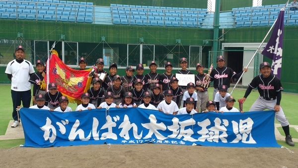 がんばれ大坂球児と書いた横断幕を持って、皆で優勝の記念写真