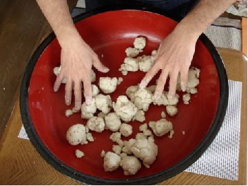 水を入れた蕎麦粉をまんべんなくかき混ぜて小さな団子のように固まっている状態の写真