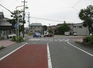 東側から西側に向かって撮影された着手前のカーブした交差点道路