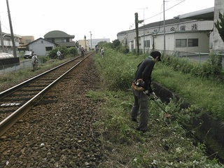 草刈り機で、線路脇の草刈りをする人たち