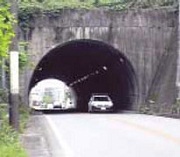現在の青田トンネルの入口、片側一車線走行で出口まで見える。