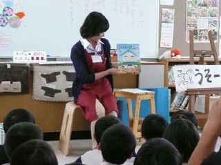 職員が原田小学校の児童の前で本の話をしている様子