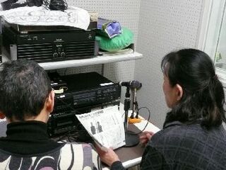 録音機材を前に広報朗読を録音している様子の写真