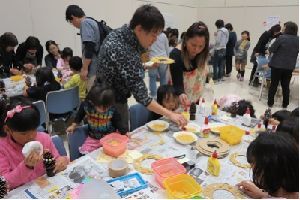 図書館長と子供たちが花のリーフを作っている様子