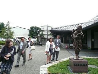 木苗教育長と教育委員の方が外にある寄贈された銅像を見ている様子