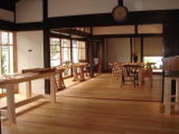 建物の中。広いフローリング。木の椅子と机を置いている