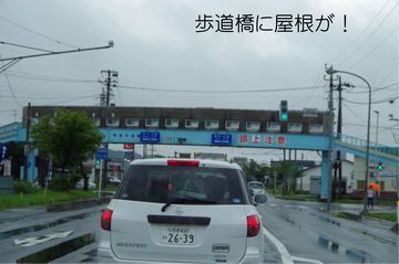 前を走る車の先には屋根のついた歩道橋が見える