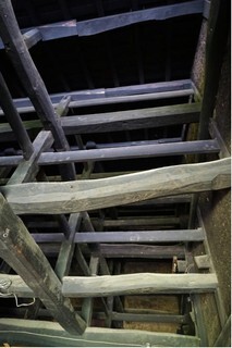 黒みがかった太い丸太の梁や貫（ぬき）が何層にも重なっているのが見える