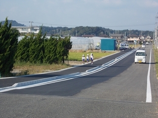 道が綺麗に舗装され車道や歩道が広く自転車や自動車が通っている様子