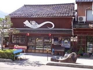 水木しげるロードにある店舗の画像で、いったんもめんに乗った鬼太郎の看板がある