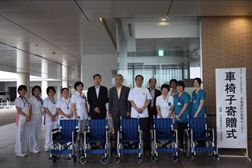 車椅子寄贈式で、寄付いただいた車椅子を前列に並べ、医師や看護師が並ぶ様子。